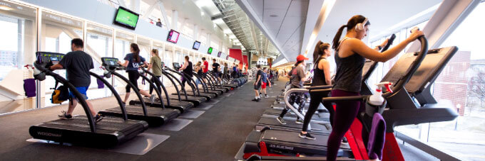 Students running on treadmills and working out in the Student Fitness Center.