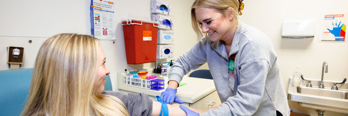 A student gets checked by a nurse at health services.